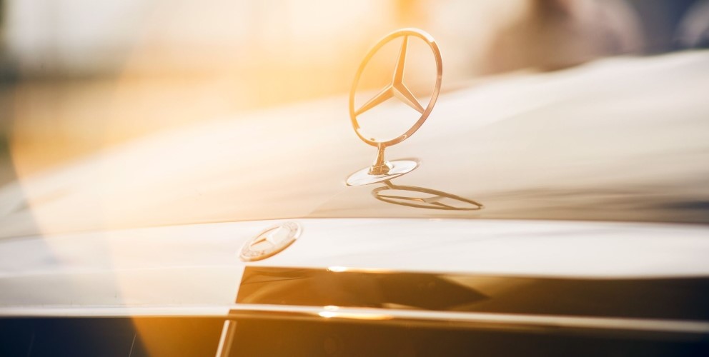 zu sehen ist der Mercedes Stern auf einem Auto 